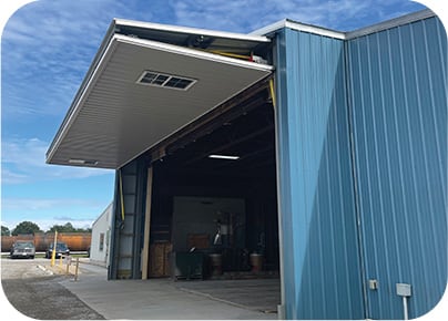 Bifold door with Schweiss Lift Straps on blue building