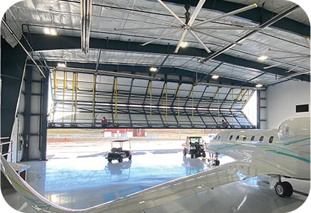 Interior view of Schweiss Lift Straps on bifold door of jet hangar