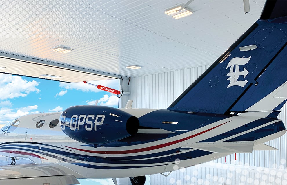 Interior view of open Schweiss hydraulic door on Econo Lumber hangar with an airplane inside