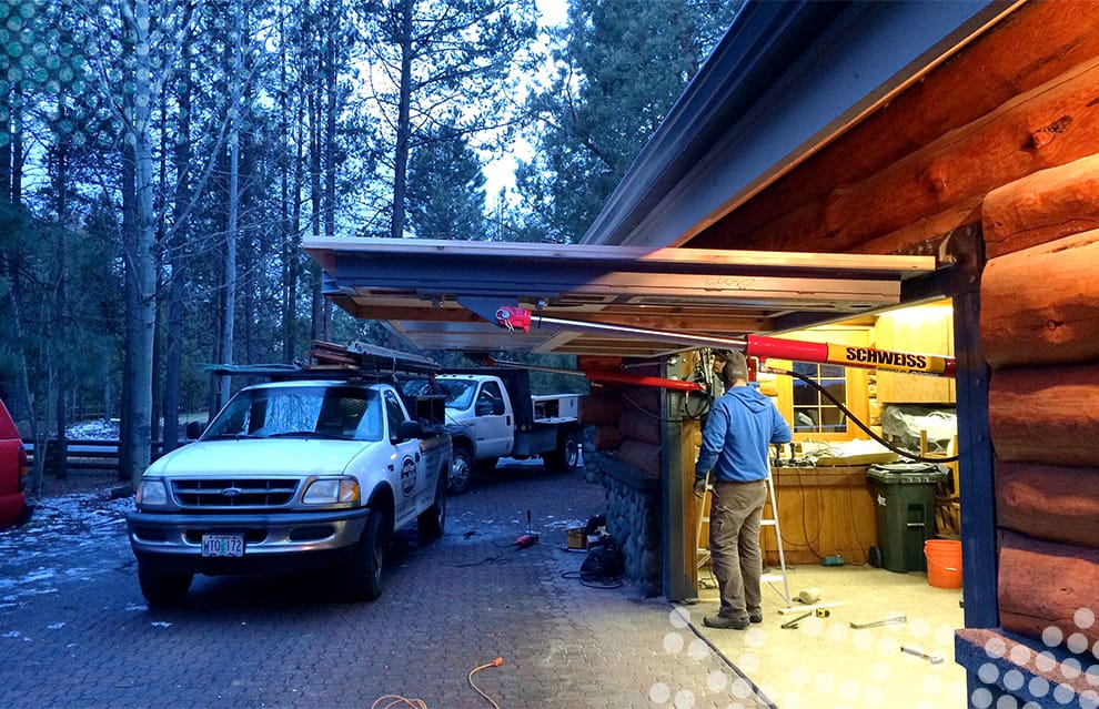 Side view of custom Schweiss hydraulic door fitted on a Log Cabin in Oregon shown open