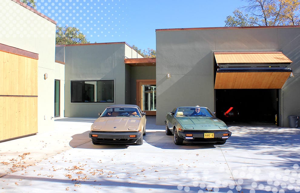 Struthers' classic British cars parked in front of his garage fitted with a custom Schweiss bifold door