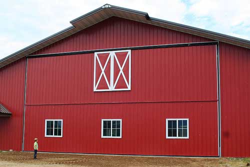 Child in awe of new Red Schweiss bifold Door storing family's equipment  