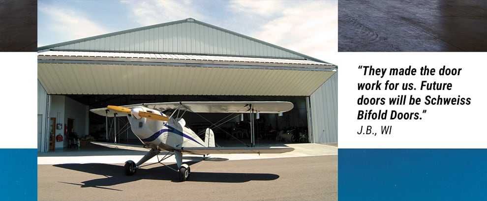 airplane infront of bifold hangar door